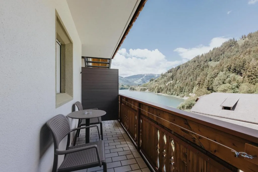 Balcone della camera con tavolino e vista sul lago e sulle montagne