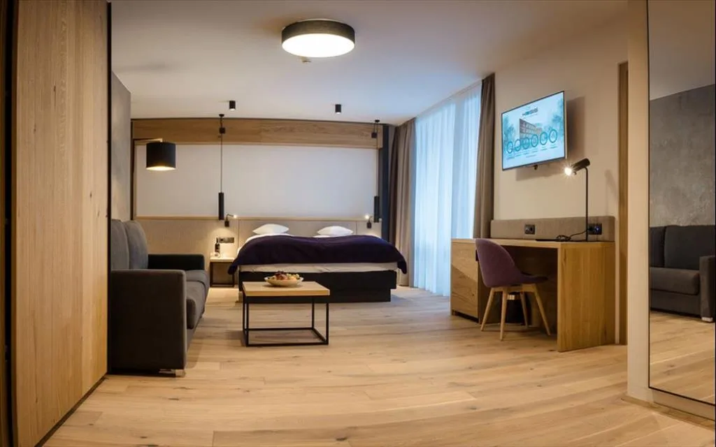 Suite moderna con letto matrimoniale, zona salotto e grandi finestre