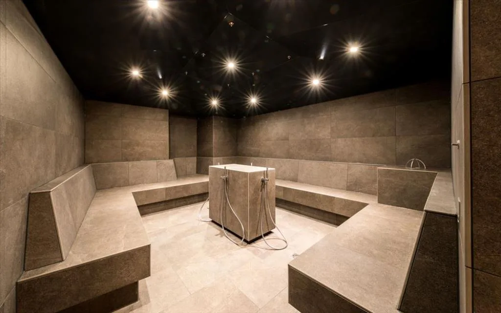 Bagno turco della spa con panche in pietra e soffitto illuminato