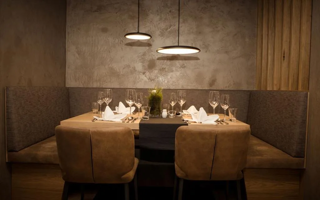 Angolo ristorante intimo con tavolo apparecchiato e illuminazione soffusa
