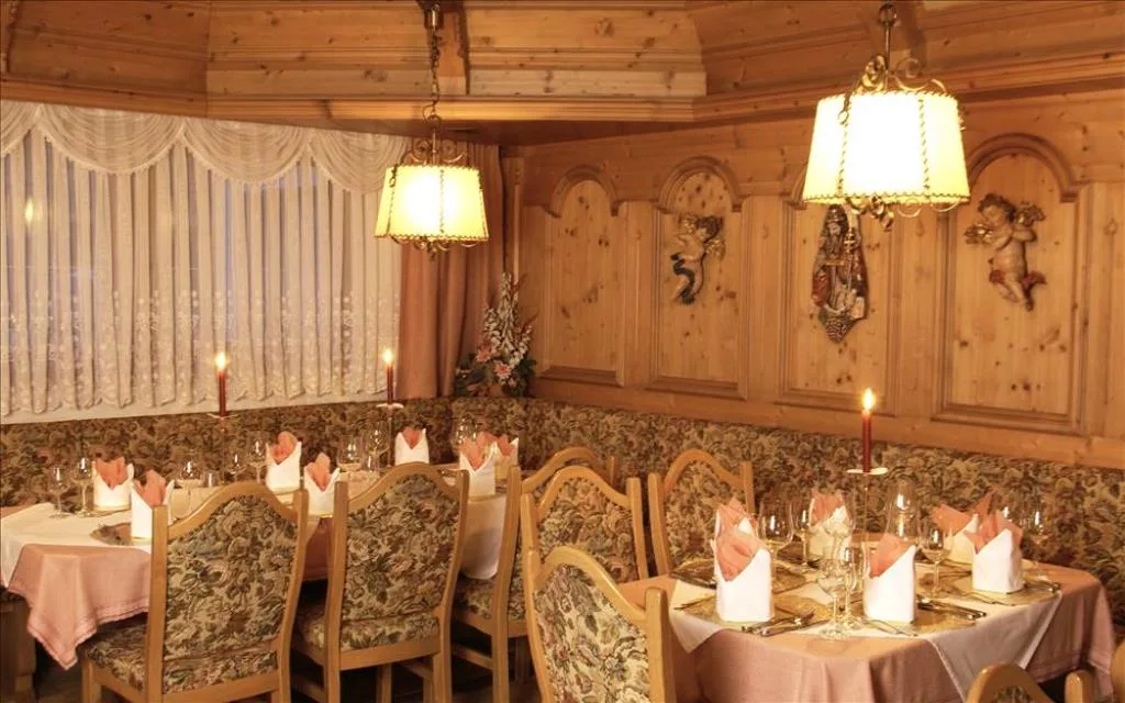 Sala ristorante rustica con pareti in legno, panche imbottite e illuminazione soffusa