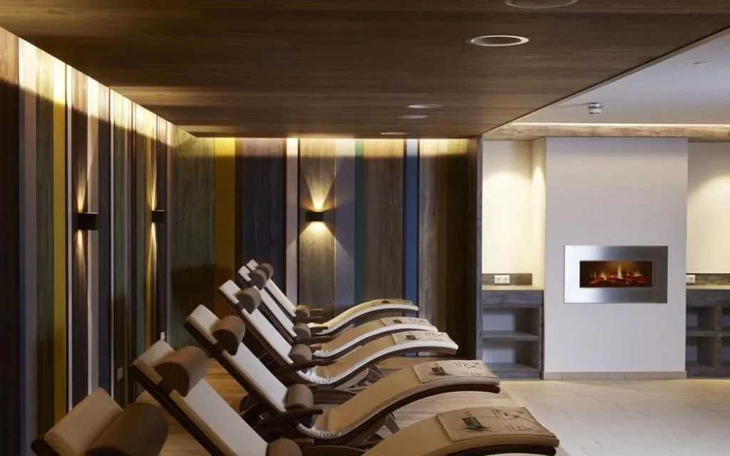 Area relax spa con lettini e parete decorativa colorata illuminata