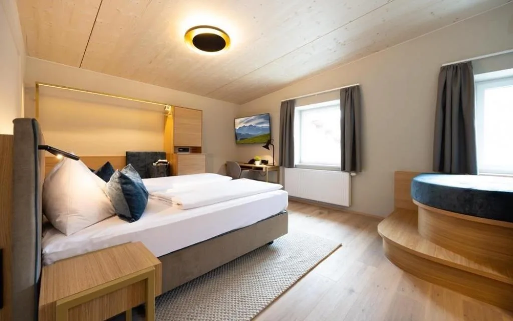 Camera matrimoniale moderna con soffitto in legno e scrivania