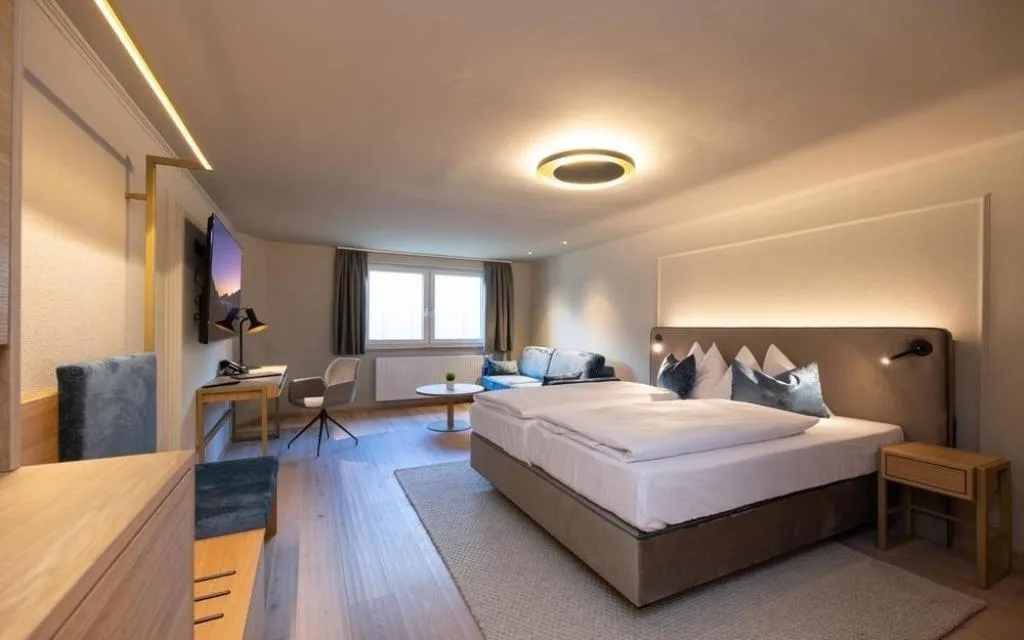 Ampia camera con letto matrimoniale, divano e area lavoro