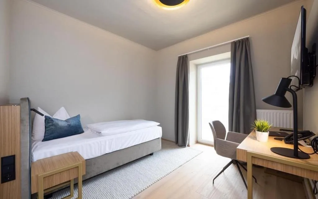 Camera singola con letto, scrivania e balcone