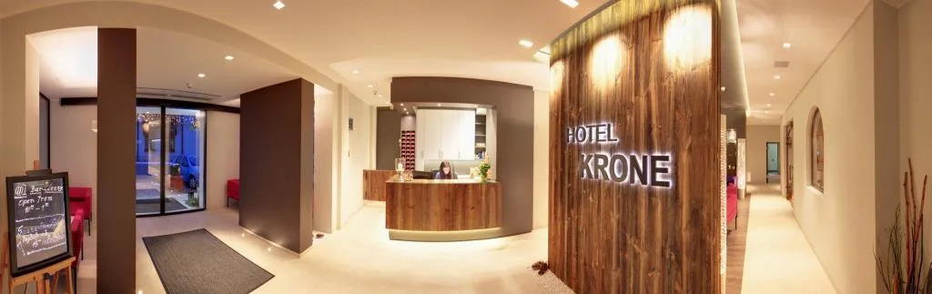 Reception dell'Hotel Krone con bancone in legno e area lounge moderna