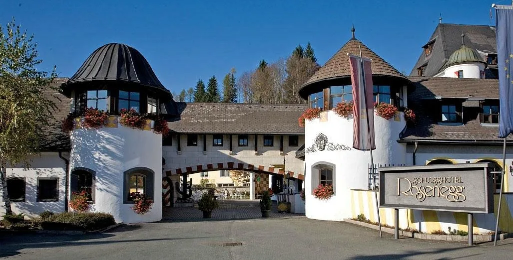 Ingresso dell'hotel con torri bianche e insegna Schlosshotel Rosenegg