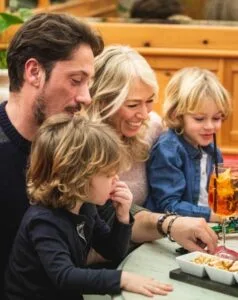 Famiglia con bambini che gioca insieme in un ambiente accogliente