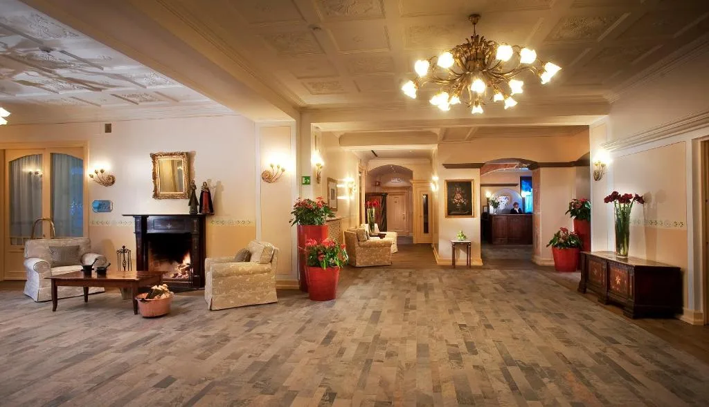 Elegante hall dell'hotel con caminetto, poltrone e lampadario dorato