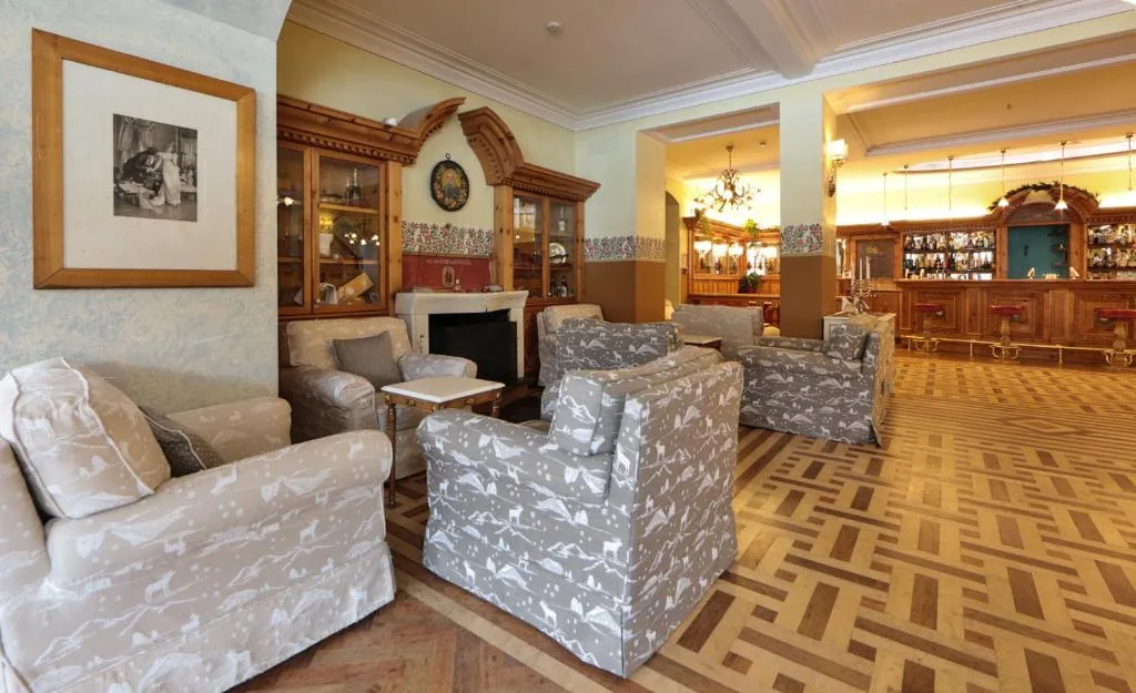 Salotto dell'hotel con poltrone, caminetto e arredamento in legno