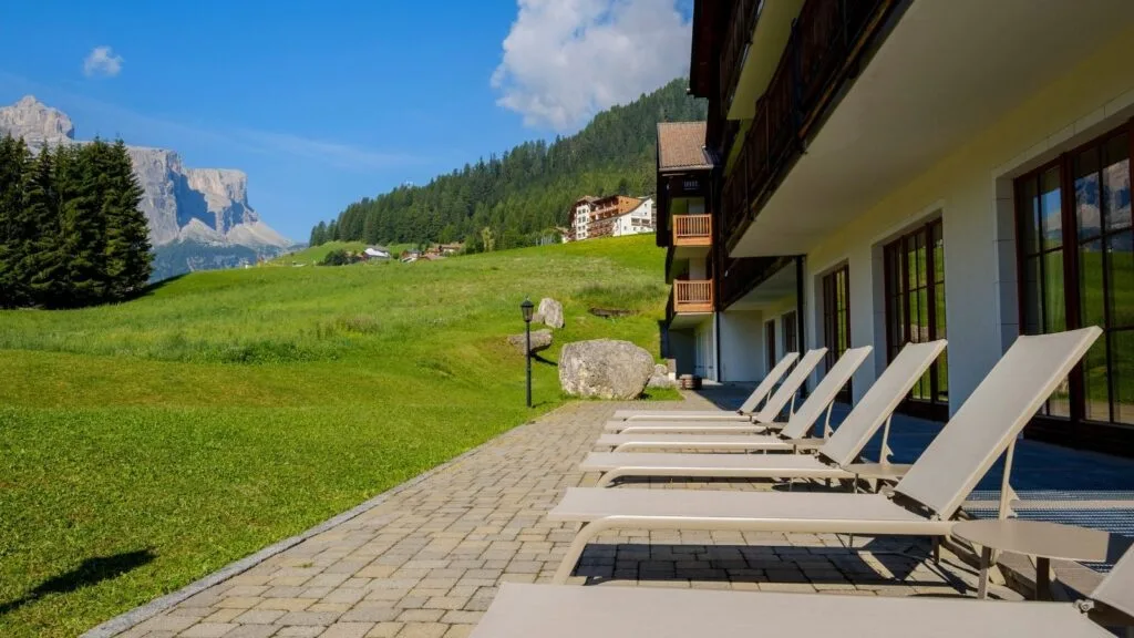 Terrazza con lettini prendisole e vista su prati e montagne