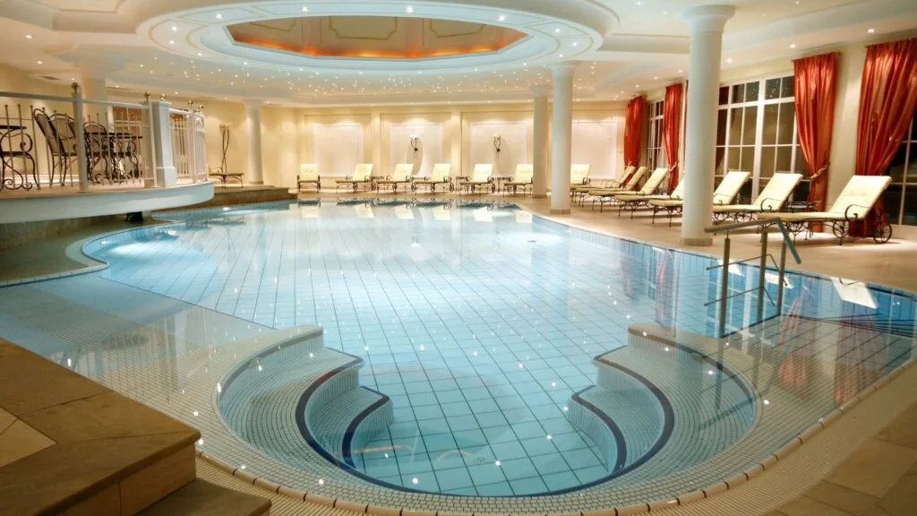 Elegante piscina coperta con soffitto illuminato e lettini