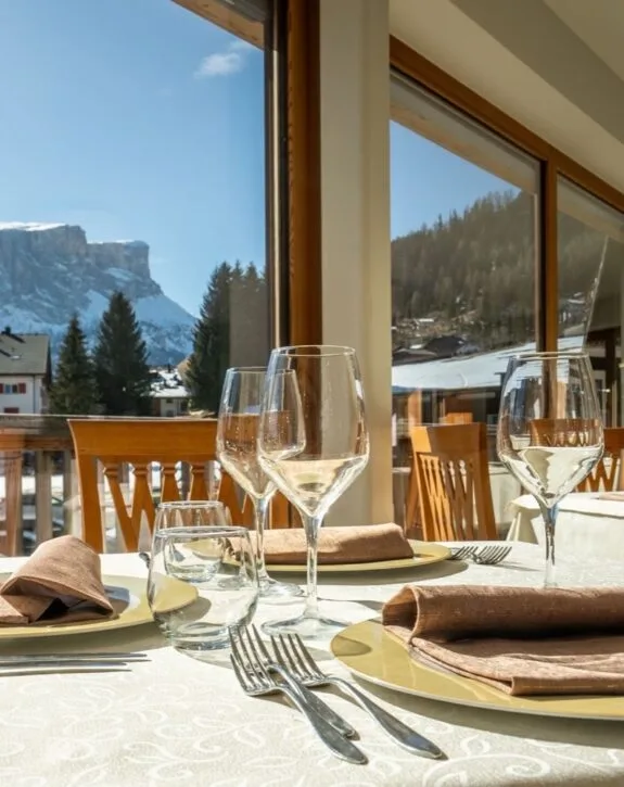 Tavolo apparecchiato con calici e vista sulle Dolomiti