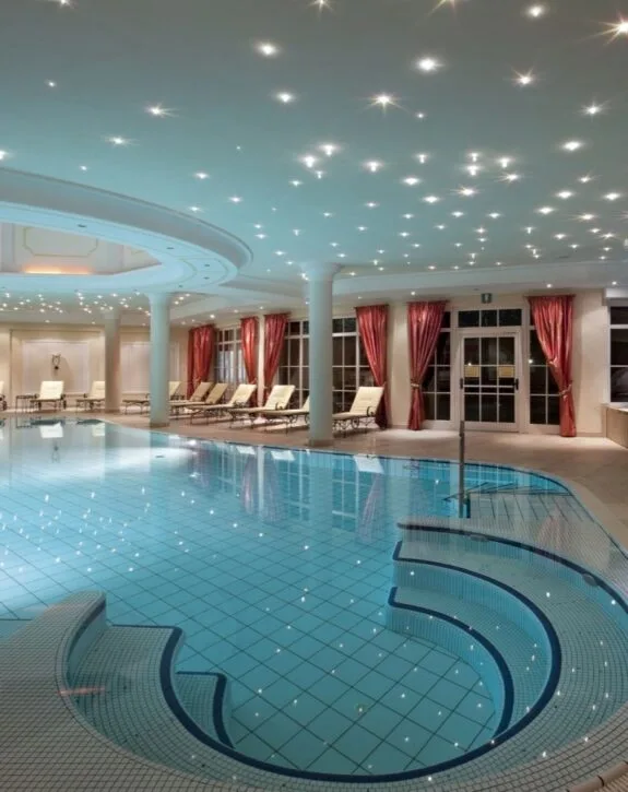 Piscina interna con soffitto a cielo stellato e tende rosse