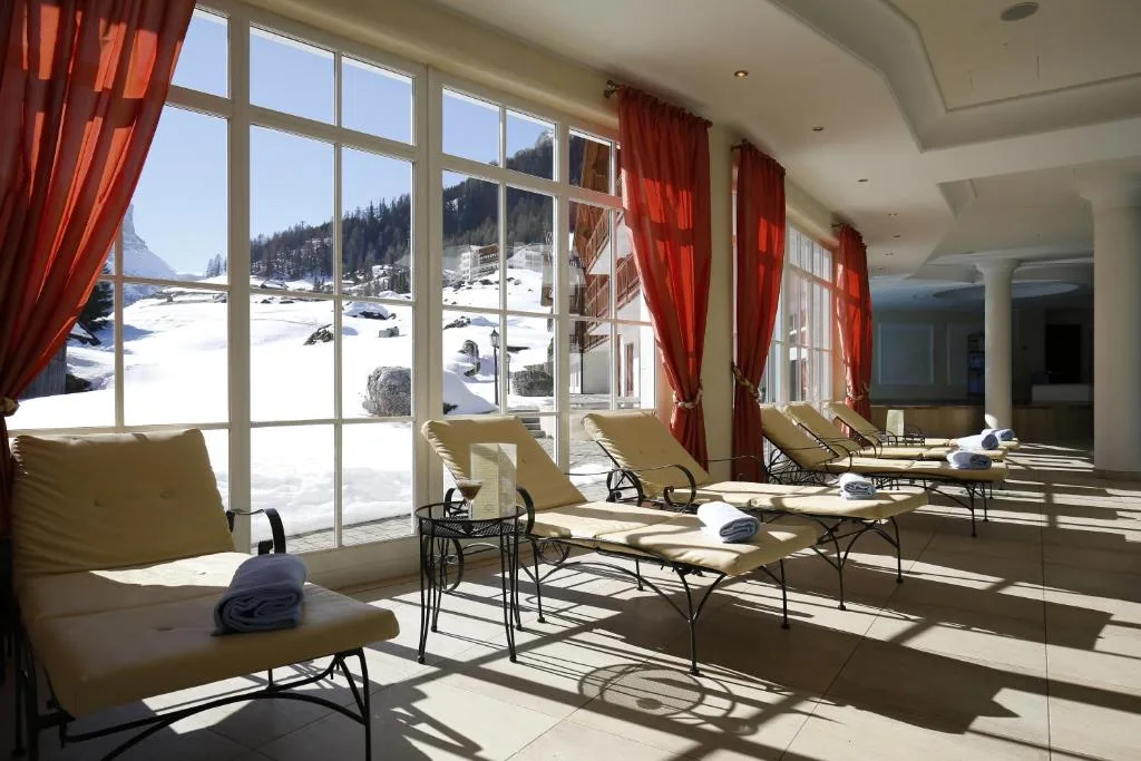 Area relax con lettini e ampie vetrate affacciate sulla neve