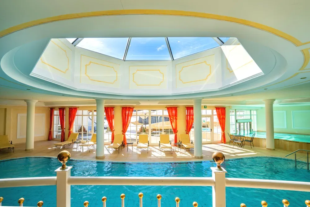 Piscina interna con lucernario a cupola e lettini relax