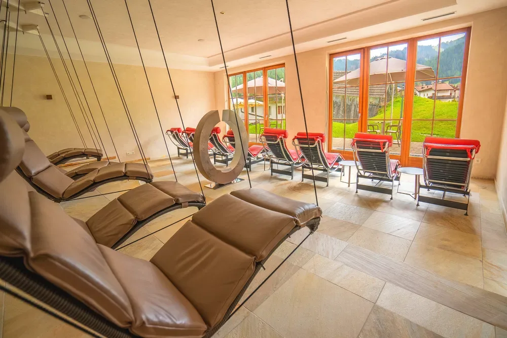 Area relax della spa con lettini sospesi e vista sui prati