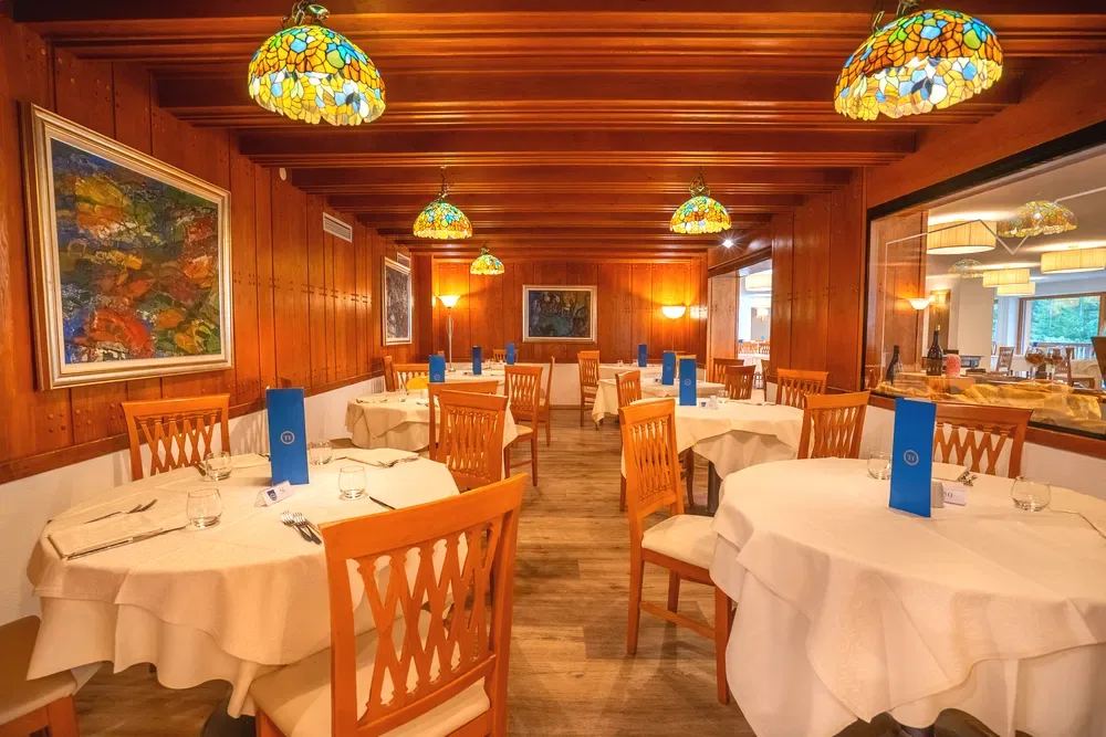 Sala ristorante con boiserie in legno e lampade Tiffany colorate