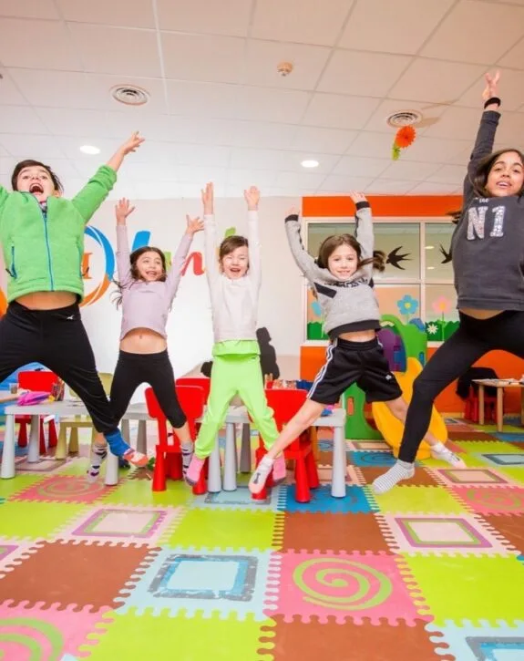 Bambini che saltano felici nella sala giochi colorata