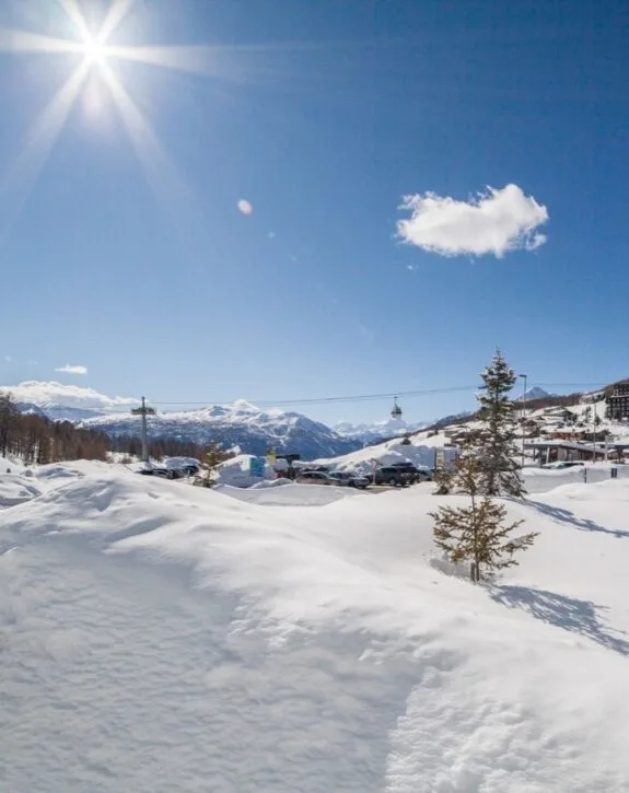 Paesaggio innevato con sole splendente e vette alpine sullo sfondo