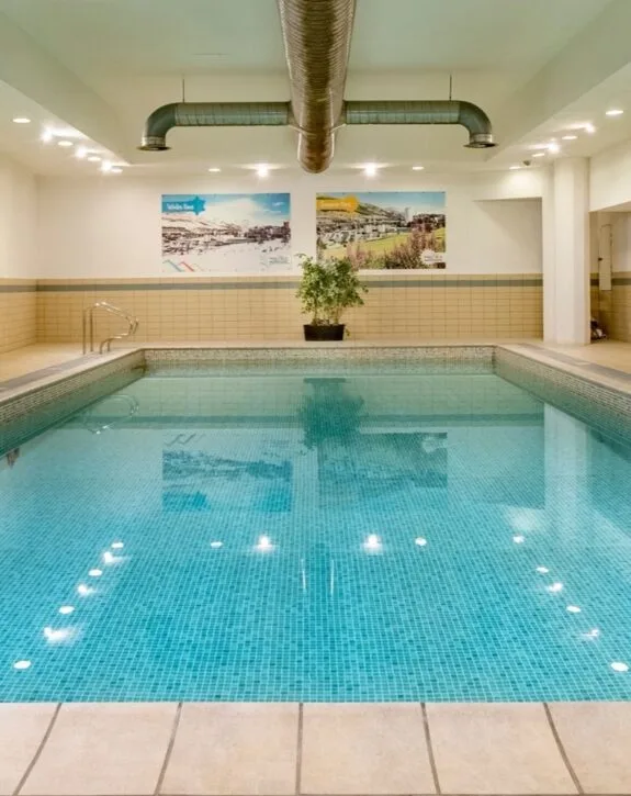 Piscina coperta con acqua turchese e pianta decorativa