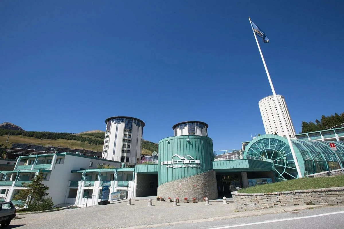 Ingresso dell'hotel con torri circolari e bandiera in giornata estiva