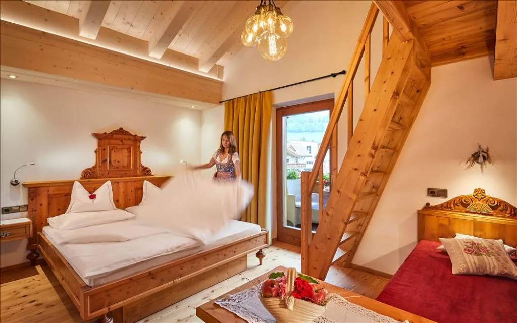 Camera con soppalco in legno, letto matrimoniale e scala interna