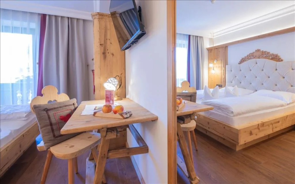 Camera con letto matrimoniale, tavolino e TV a parete
