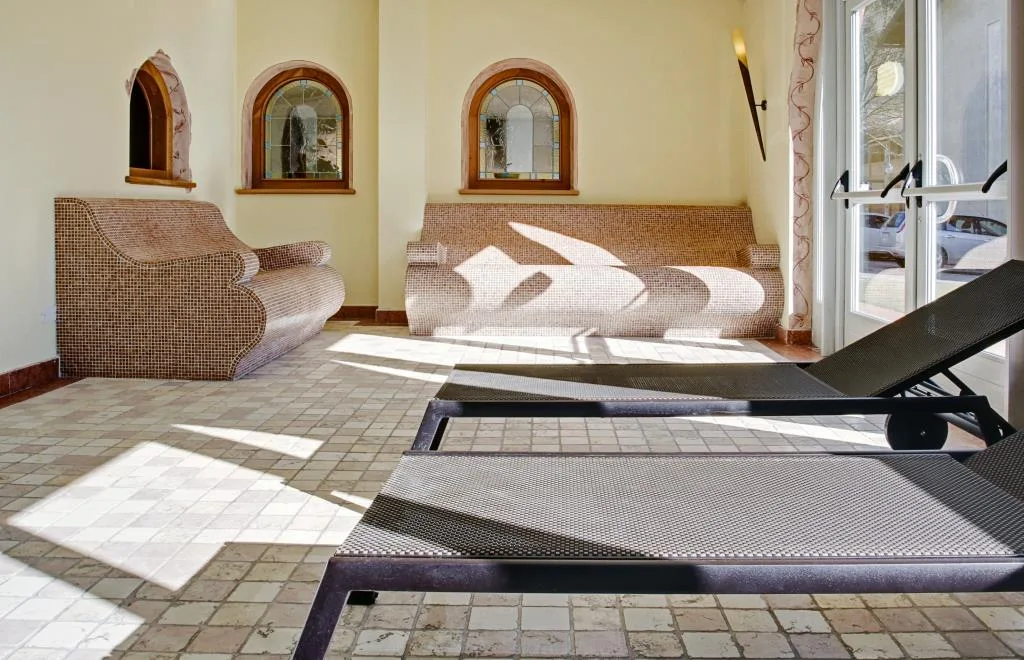 Area relax della spa con lettini in mosaico riscaldati e finestre ad arco