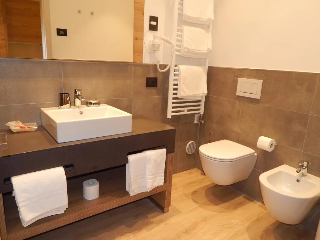 Bagno moderno con lavabo squadrato, wc, bidet e pavimento in legno