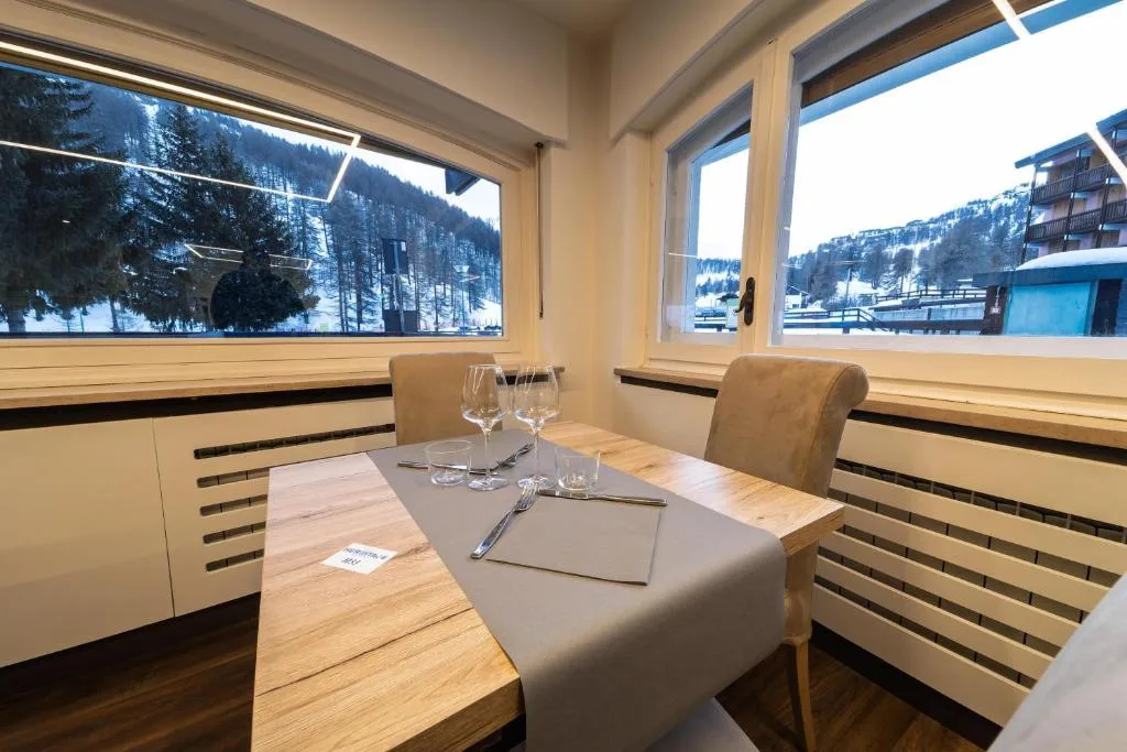 Tavolo apparecchiato accanto alle finestre con vista sulla neve