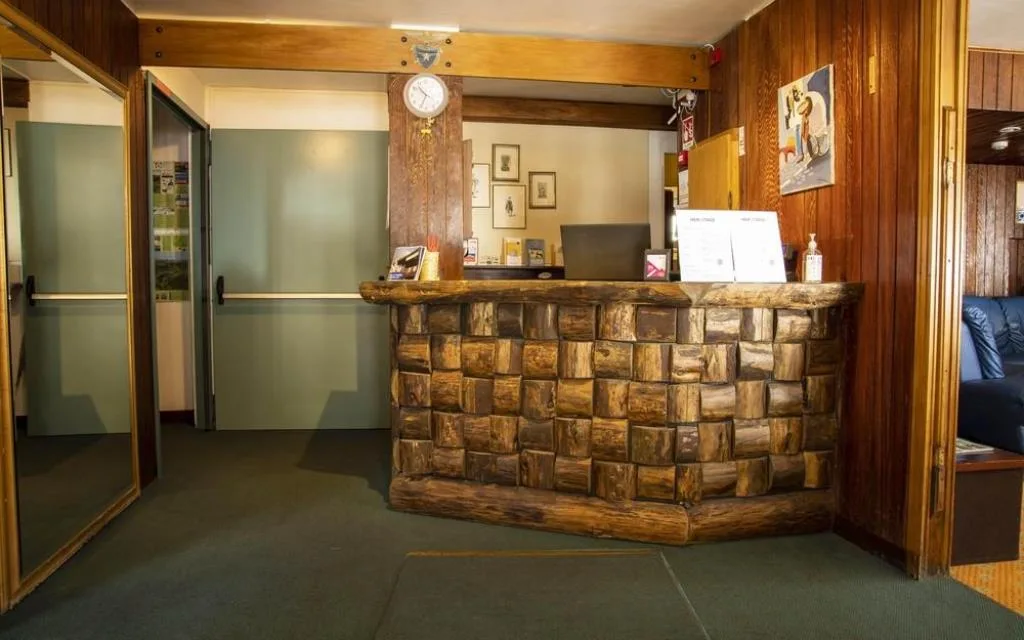 Reception dell'hotel con bancone in legno rustico e orologio a pendolo