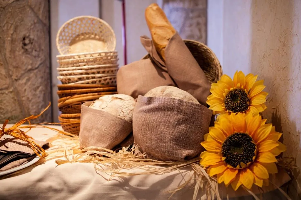 Cestini di pane fresco e girasoli decorativi su tavolo del buffet