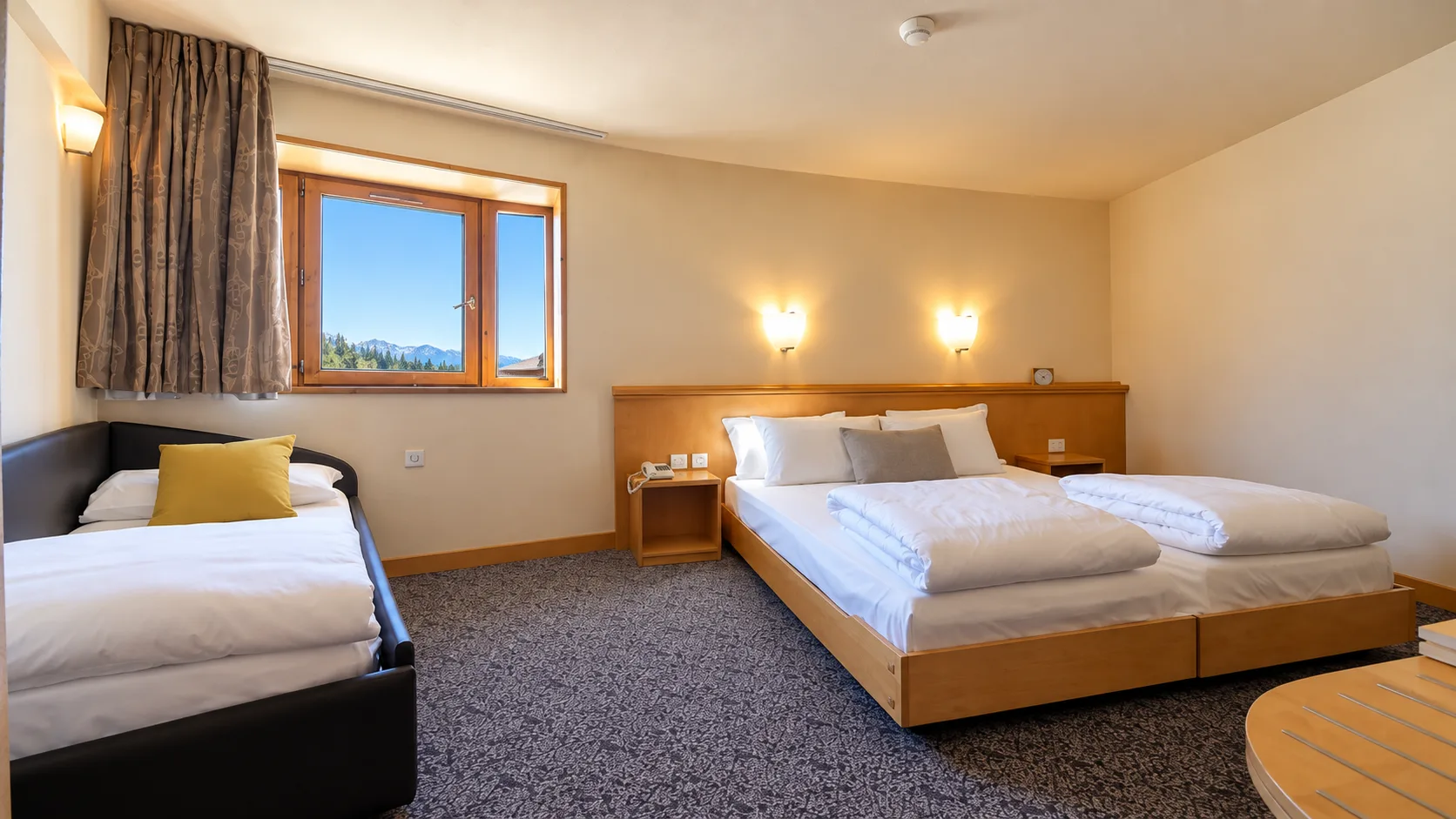 Camera familiare con letto matrimoniale e divano letto singolo, finestra con vista montana