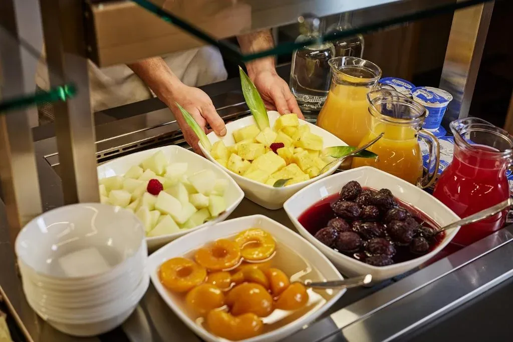 Buffet della colazione con frutta fresca, composte e succhi
