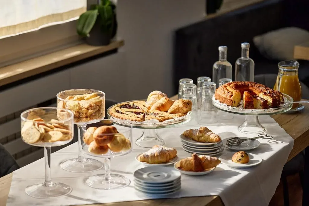Tavolo con dolci da colazione, croissant, crostata e torta