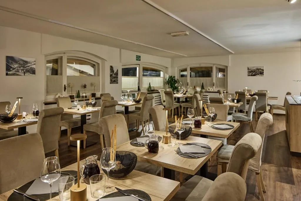 Sala ristorante accogliente con tavoli apparecchiati e illuminazione soffusa