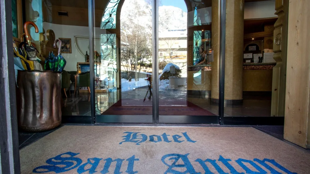 Ingresso dell'Hotel Sant'Anton con zerbino personalizzato e porte a vetri