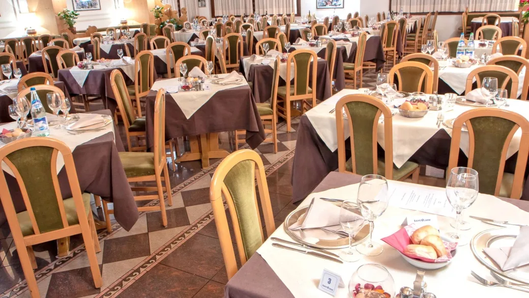 Ampia sala ristorante con tavoli apparecchiati e pavimento decorato