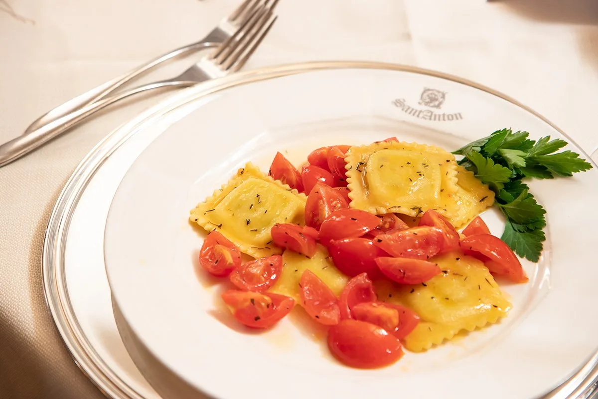 Piatto di ravioli con pomodorini freschi e prezzemolo nel ristorante Sant'Anton
