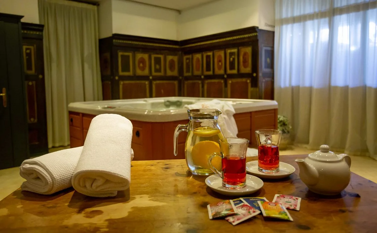 Area benessere con vasca idromassaggio e tavolino con tè e asciugamani