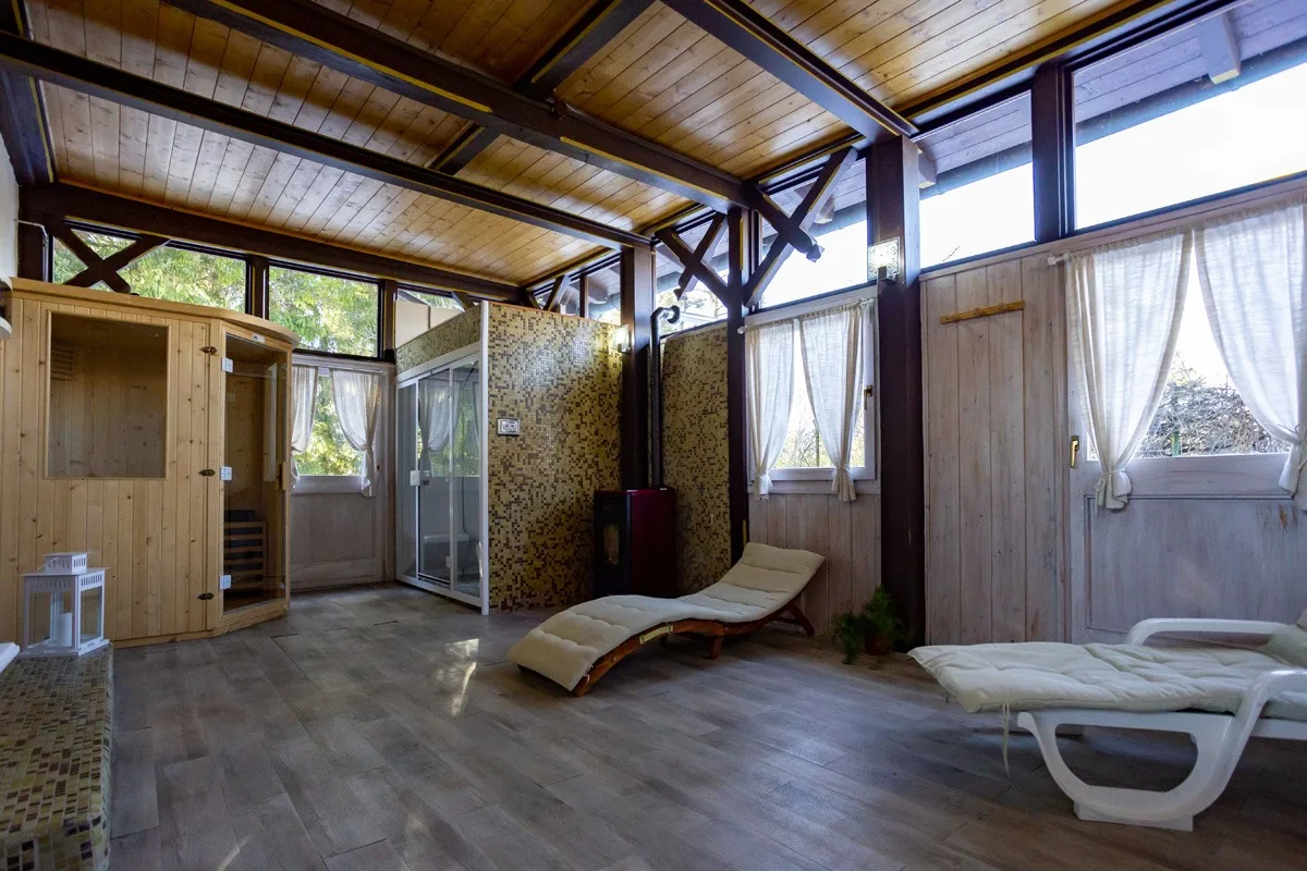 Zona relax della spa con sauna in legno, lettini e luce naturale dalle finestre