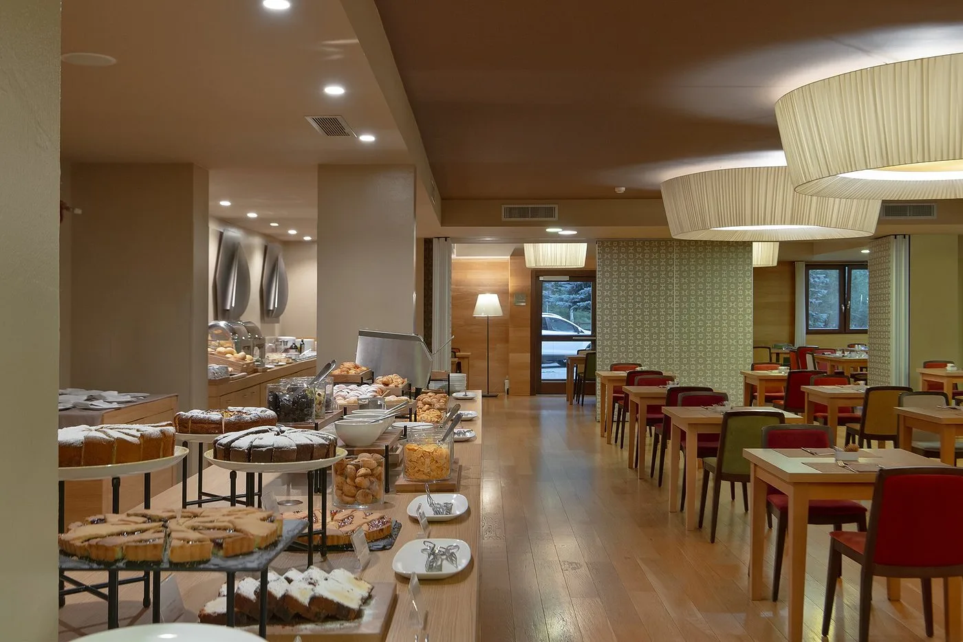 Sala colazione con ricco buffet di dolci e torte e tavoli apparecchiati
