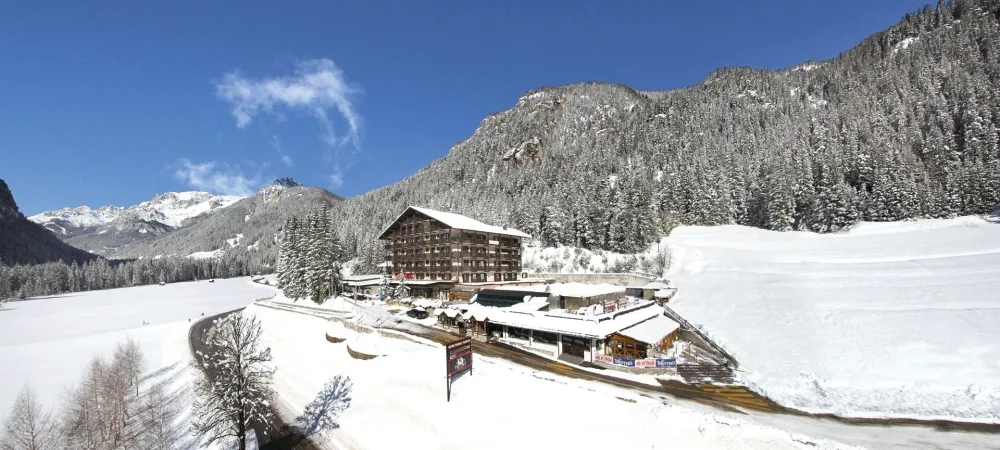 Vista panoramica dell'hotel circondato da boschi innevati e montagne