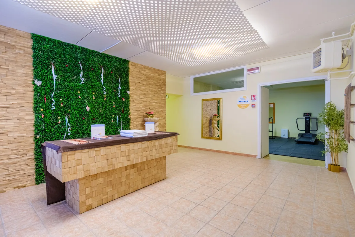 Reception del centro benessere con parete verde e accesso alla palestra