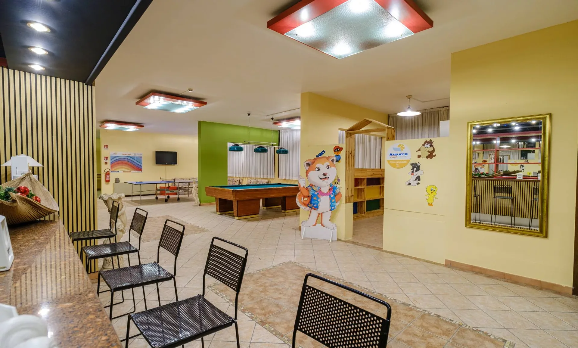 Area giochi per bambini con ping pong, biliardo e angolo lettura