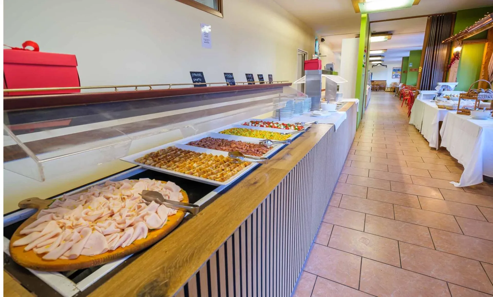 Buffet con affettati, verdure e pietanze varie nella sala ristorante