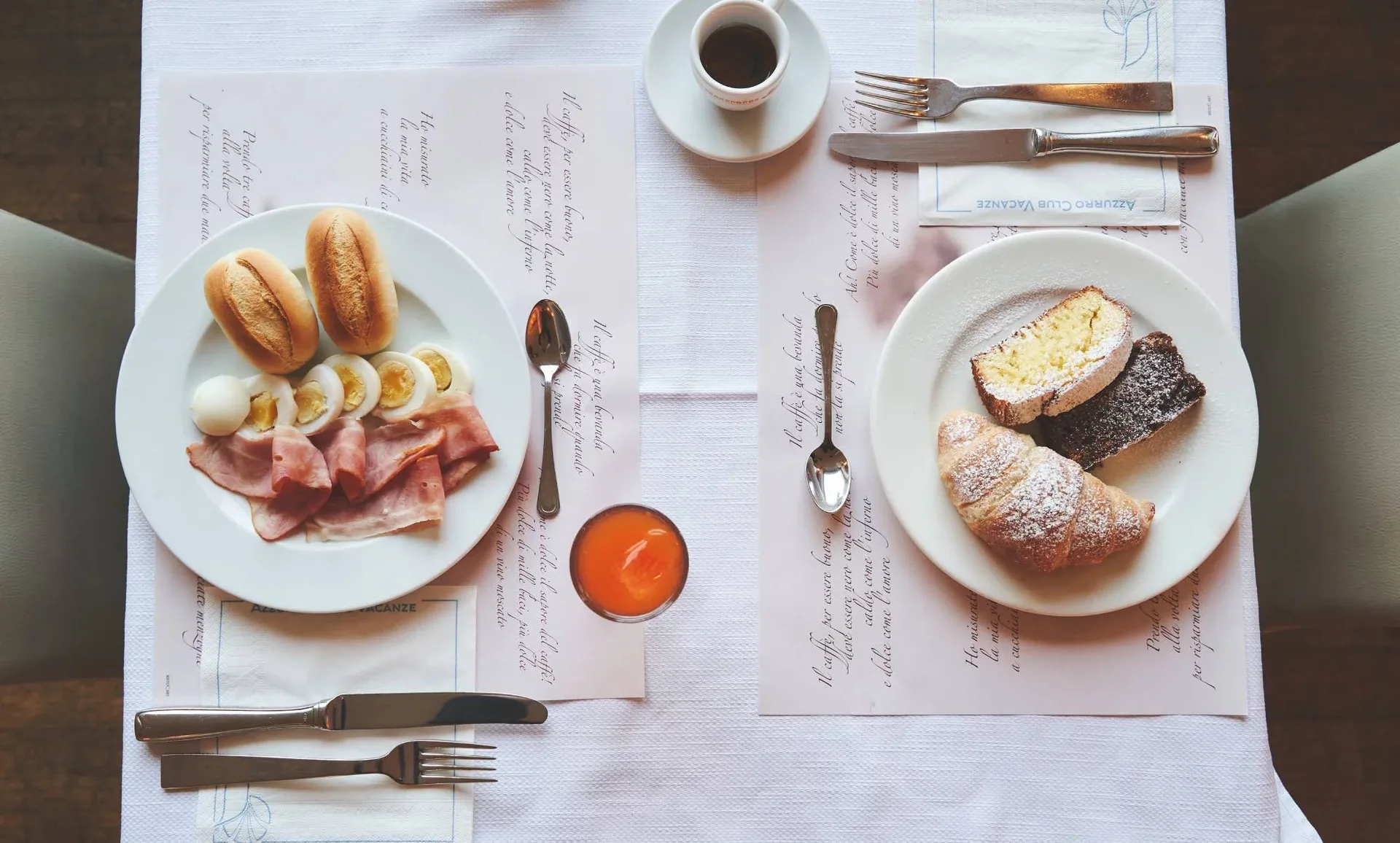 Colazione servita con affettati, uova, cornetto e caffè