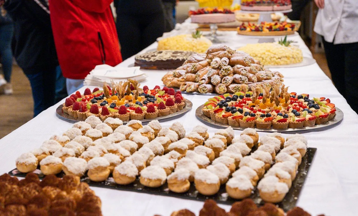 Tavolo con ricca selezione di dolci, crostate di frutta e bignè