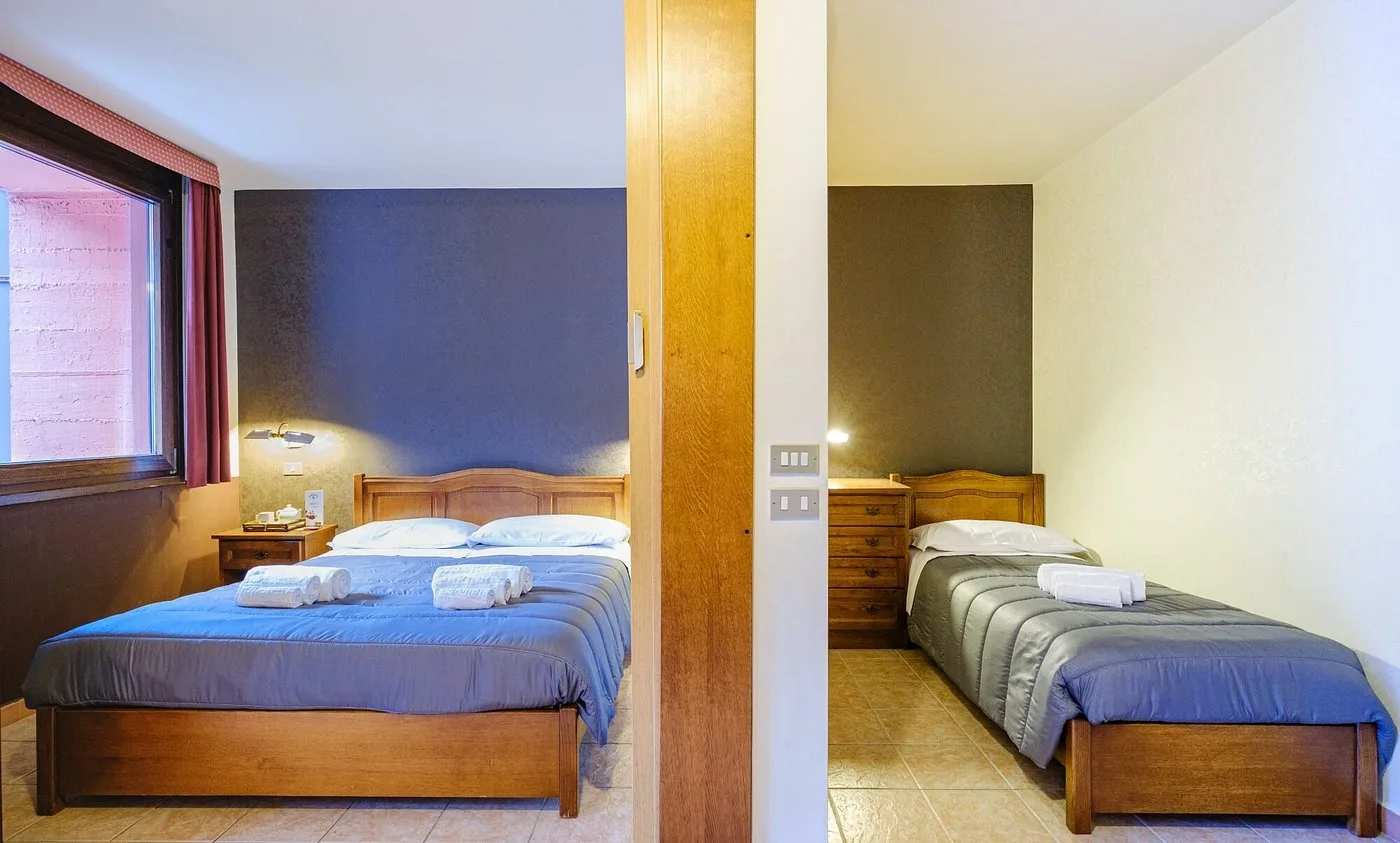 Camera con letto matrimoniale e letto singolo in ambienti comunicanti